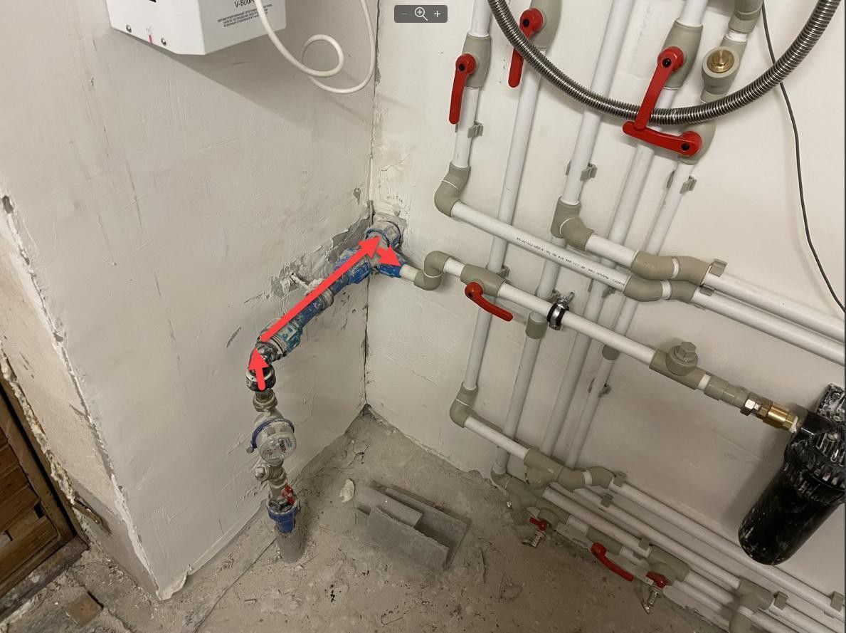 Complex plumbing and electrical wiring installed on an unfinished utility room wall.