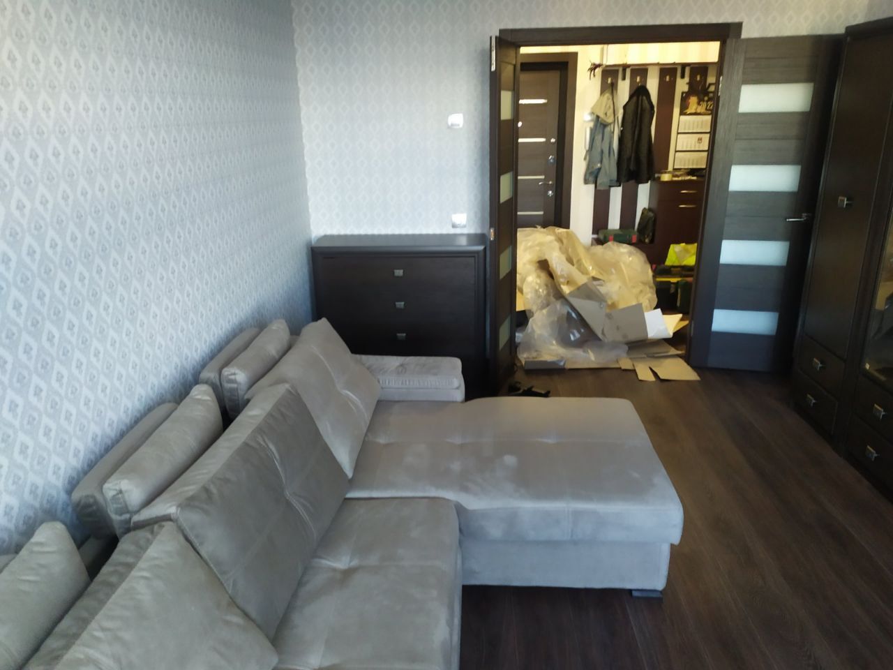 Grey L-shaped sectional sofa in a living room with dark wood floors.