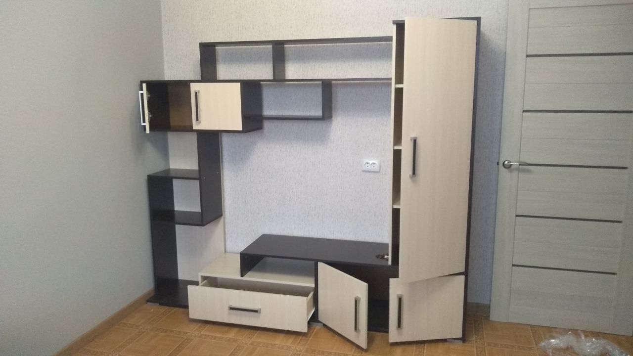 Modern modular wall unit with dark and light wood sections, open cabinets and drawers.